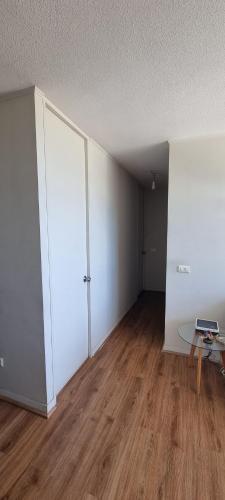 una habitación vacía con una mesa y una puerta blanca en Edu Apartment, en Concepción