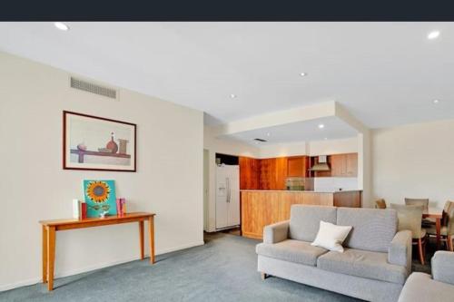 a living room with a couch and a table at Three bedroom apartment in Sebel complex- on site restaurant, room service, gym and parking in Launceston