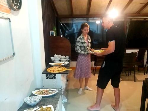 a man and a woman holding a plate of food at Liberty Guesthouse Maldives in Mahibadhoo