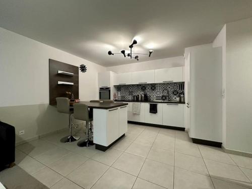 une cuisine avec des armoires blanches et une table à l'intérieur dans l'établissement HeberGeneve : Domaine de Rochat, à Prévessin-Moëns