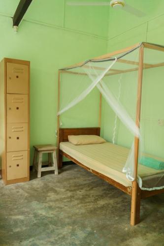a bedroom with a canopy bed and a stool at Little Bay Arugam Bay in Arugam Bay