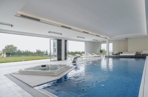 a swimming pool with a tub in a house at Conimbriga Hotel do Paço in Condeixa a Nova