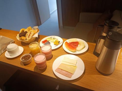 ein Tisch mit Tellern voller Essen und Gläsern mit Orangensaft in der Unterkunft Salinas Premium Resort in Salinópolis