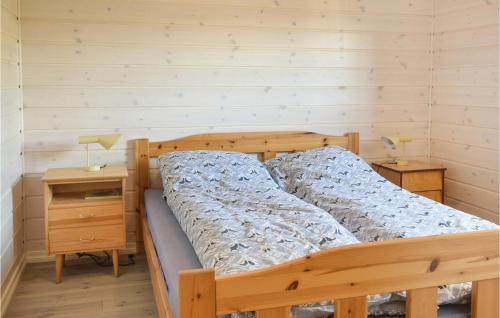 a bedroom with a wooden bed and a night stand at Nice Home In Sjusjen With 3 Bedrooms And Sauna in Sjusjøen