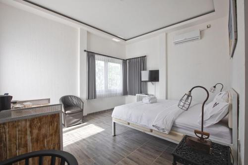 1 dormitorio con cama, escritorio y silla en ImahBC Surfcamp, en Tabanan