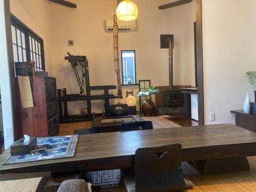 奄美市にあるゲストハウスナゼの木製テーブルと椅子が備わる広い客室です。
