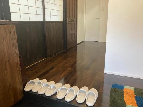 a row of white shoes sitting in a room at ゲストハウスナゼ in Amami