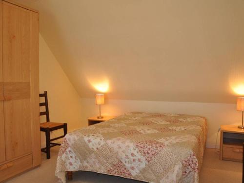 トレガステルにあるAppartement Trégastel, 2 pièces, 2 personnes - FR-1-368-19のベッドルーム1室(ベッド1台、椅子、ランプ2つ付)