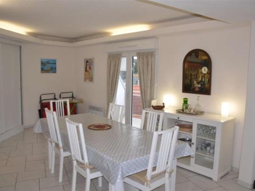 une salle à manger avec une table et des chaises blanches dans l'établissement Superbe duplex au centre de Trégastel avec WiFi et garage privé - FR-1-368-52, à Trégastel