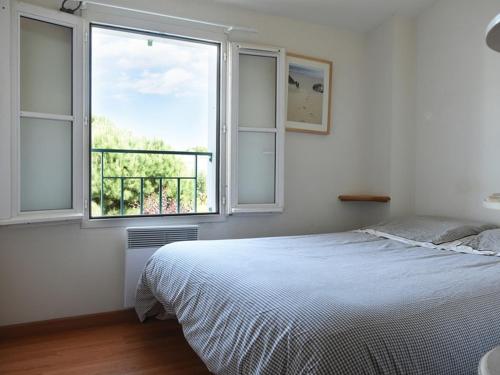 ein Schlafzimmer mit einem Bett und einem großen Fenster in der Unterkunft Maison Ars-en-Ré, 3 pièces, 4 personnes - FR-1-434-5 in Ars-en-Ré