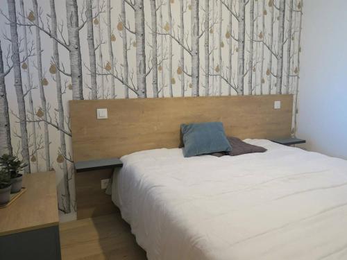 - une chambre avec un lit et un mur arboré dans l'établissement Appartement rénové avec balcon, parking et accès direct à la plage de Trestraou - Perros-Guirec - FR-1-368-260, à Perros-Guirec