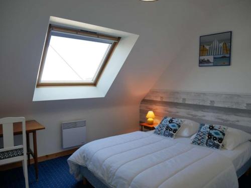 Schlafzimmer mit einem großen Bett und einem Fenster in der Unterkunft Villa Erdeven, 5 pièces, 8 personnes - FR-1-479-14 in Erdeven