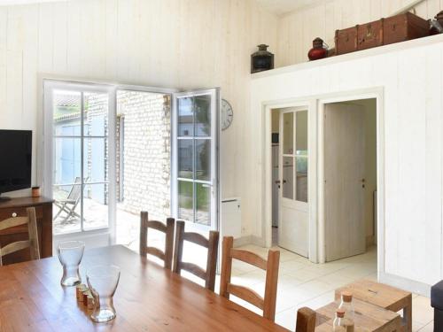 un salon avec une table, des chaises et une télévision dans l'établissement Maison cosy près du centre des Portes-en-Ré, 2 chambres, forfait ménage inclus - FR-1-434-73, aux Portes