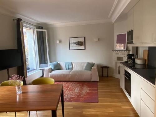 un salon avec un canapé et une table dans l'établissement Coeur de Montorgueil angle Tiquetonne ensoleillé, à Paris