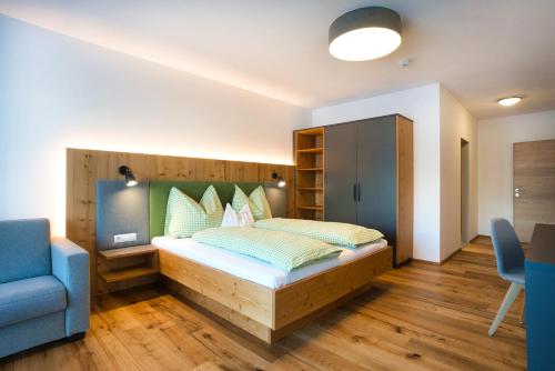 a bedroom with a bed and a blue chair at Hotel Breilerhof in Schladming