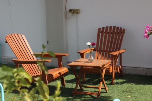 duas cadeiras e uma mesa com um vaso de flores em Abu Rakan Apartment em Mascate