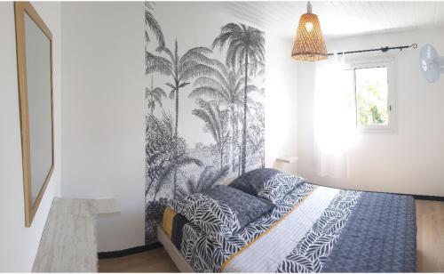 a bedroom with a bed with a black and white wallpaper at Lilie location langevin in Saint-Joseph