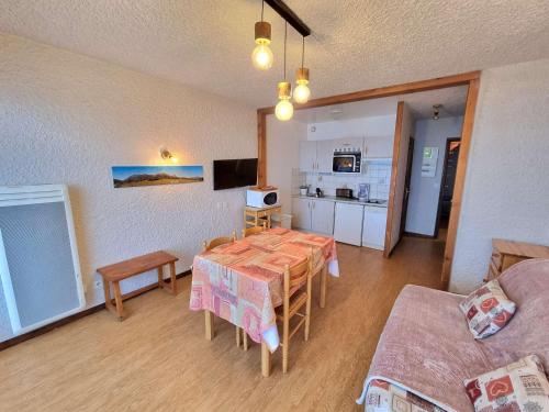 un salon avec une table et une cuisine dans l'établissement Appartement 4 pers, balcon sud, parking, wifi, animaux admis - FR-1-393-3, à Saint-Michel-de-Chaillol