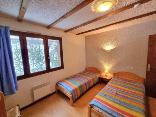 une chambre avec un lit et une fenêtre dans une pièce dans l'établissement Appartement 4 pers, balcon sud, parking, wifi, animaux admis - FR-1-393-3, à Saint-Michel-de-Chaillol