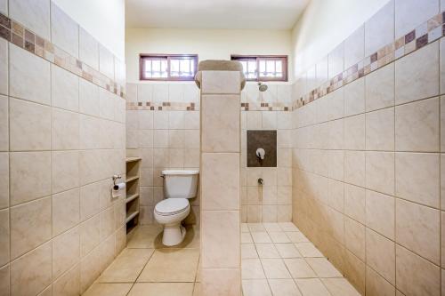 a bathroom with a toilet and tiled walls at Villa Casiopea in Carpintero