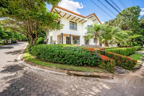 a house on a street with bushes and flowers at Villa Casiopea in Carpintero