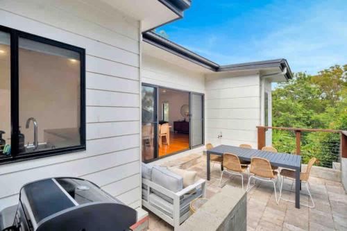 a house with a patio with a table and chairs at Spacious modern 3 bdr home minutes from beach in Merewether