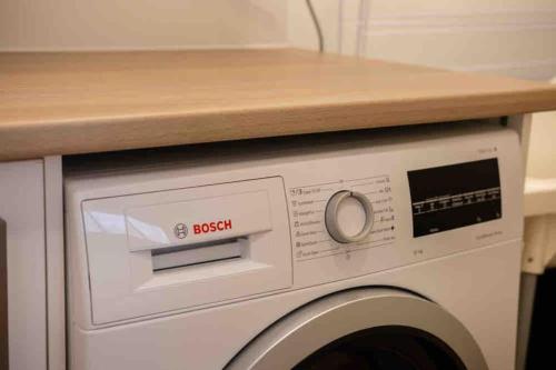 a white washing machine with a counter on top of it at Spacious modern 3 bdr home minutes from beach in Merewether