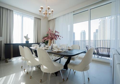 uma sala de jantar com uma mesa preta e cadeiras brancas em Nasma Luxury Stays - Harbour Gate Tower 1 em Dubai