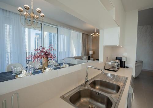 uma cozinha com um lavatório e uma sala de estar em Nasma Luxury Stays - Harbour Gate Tower 1 em Dubai