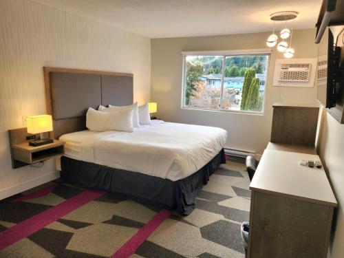 um quarto de hotel com uma cama e uma janela em The Spot at Porpoise Bay em Sechelt