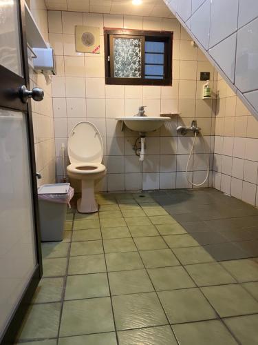 a bathroom with a toilet and a sink at Nuan Hostel in Xiaoliuqiu