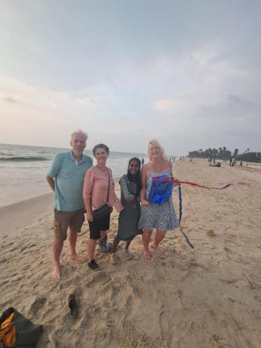 a group of people standing on the beach at Marari Bethsaida Homestay in Shertallai