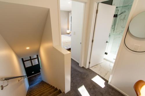 a staircase leading to a bedroom and a bathroom at New Boutique Central Sanctuary near Latimer Square in Christchurch