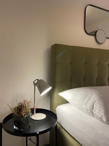 a bedroom with a bed and a table with a lamp at Comfort 1 and 2BDR Apartment close to Zurich Airport in Zürich