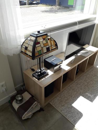 a lamp on a table in a room with a window at Thorbecke Canal View 42m2 Loft in Zwolle