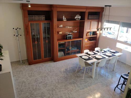 a dining room with a table with white chairs at VV 'TIRBA' Precioso duplex a 1 minuto de la playa in Gran Tarajal