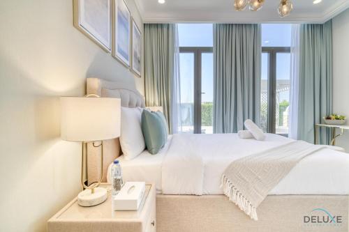 ドバイにあるSignature 6BR Villa with Assistant Room and Private Pool in Frond F Palm Jumeirah by Deluxe Holiday Homesの大きな白いベッドと窓のある寝室