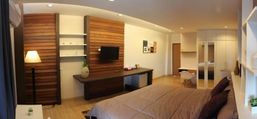 a bedroom with a bed and a desk with a computer at Villa Rassada Nakorn Lampang in Lampang