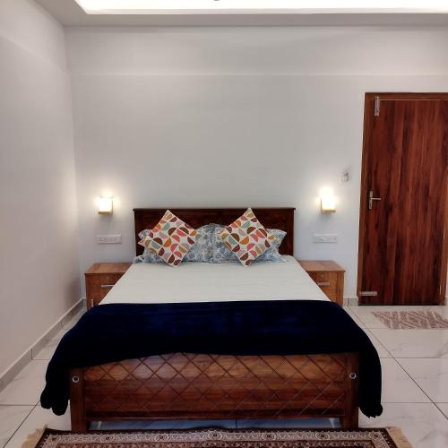 a bedroom with a large bed with two pillows at BEN COTTAGE in Thekkady