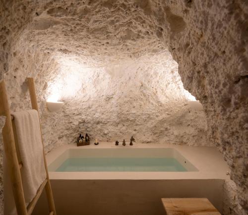 y baño con bañera en una pared de piedra. en Carmen del Azahar by Florentia Homes, en Granada