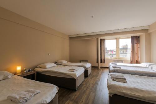 a room with four beds and a window at Ambassador Suites Antwerp in Antwerp
