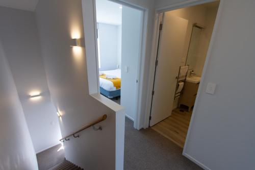 a bedroom with a mirror and a bed in a room at Peaceful Central City 2 bed pad w/carpark in Christchurch