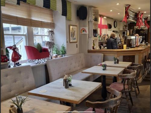 a restaurant with wooden tables and chairs and a counter at Bird In Bush Elsdon in Elsdon