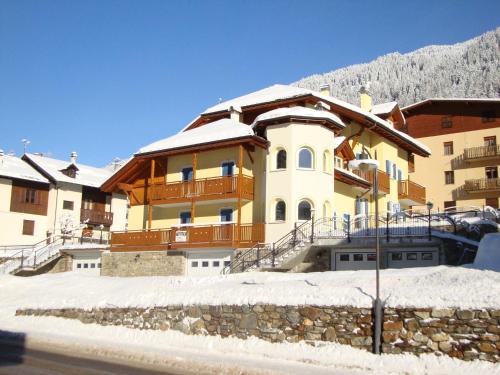 a large yellow building with snow on the ground at Appartamenti Vegaia in Peio