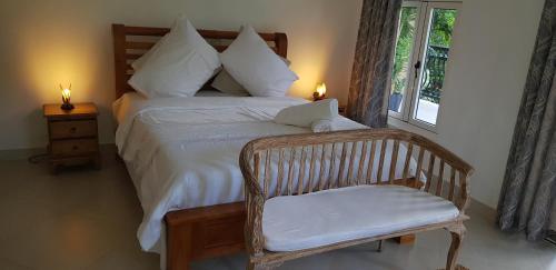sypialnia z łóżkiem z krzesłem i oknem w obiekcie SOUTH HILL VILLA w Mahé