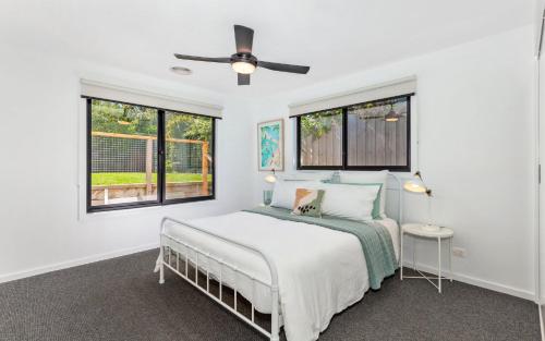 a white bedroom with a bed and two windows at Sunset Shack - Sleeps 6 - Dog friendly! in Ocean Grove