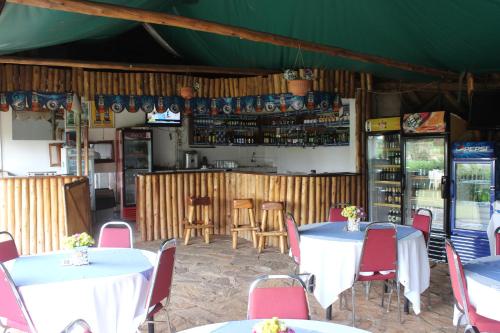 a restaurant with tables and chairs and a bar at Sky Hotel International in Kampala