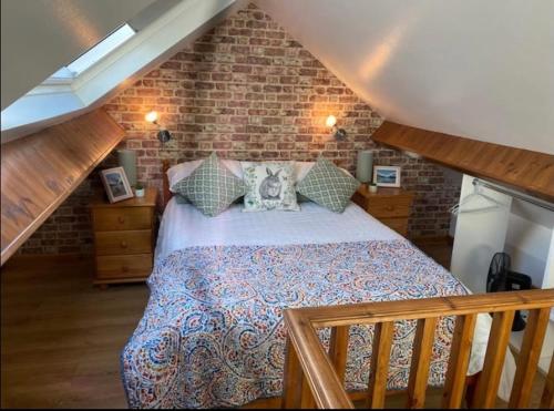 1 dormitorio con cama y pared de ladrillo en Tegfan Victorian terrace Cottage Snowdonia Llanberis, en Llanberis