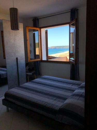 um quarto com uma cama e vista para a praia em La Villa dell Artista con vista mare e dune - IUN Q7440 em Torre dei Corsari