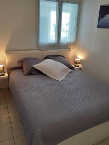 - une chambre avec un lit avec deux oreillers et une fenêtre dans l'établissement Les Rivages de Rochelongues, T3, piscine, clim, parking, au Cap d'Agde